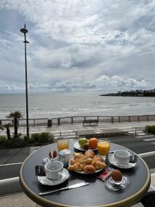 - une table avec de la nourriture et une vue sur la plage dans l'établissement Hôtel The Originals Miramar, Royan Pontaillac, à Royan