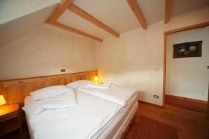 1 dormitorio con 1 cama blanca en una habitación en Kronau Chalet Resort, en Kranjska Gora