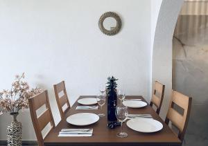 a wooden table with plates and wine glasses on it at Thalassa Beach Kavala in Paleo Tsifliki