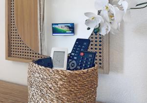 a basket with a cell phone and a flower at Thalassa Beach Kavala in Paleo Tsifliki