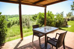 een tafel en 2 stoelen op een patio met uitzicht bij Country House Poggio Aione in Catabbio