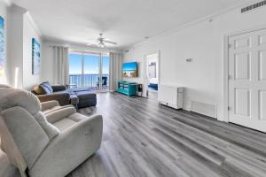 a living room with a couch and a chair at Ocean Reef 904 by Emerald Coast Retreats in Panama City Beach