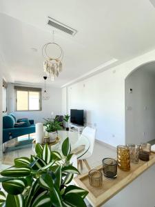 sala de estar blanca con mesa y sofá en Casa Ralphie, en Santa Pola
