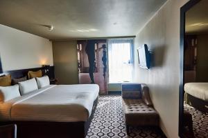 サウスポートにあるThe Vincent Hotelのベッドとテレビ付きのホテルルーム