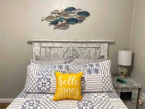a bedroom with a bed with pillows and a clock at Casita de la Playa - 2 Bikes & Assateague Pass in Ocean City