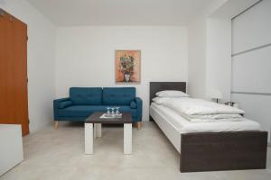 a living room with a blue couch and a table at Penzion u Hanky in Telgárt