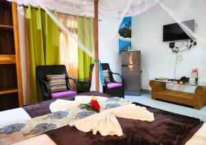 ein Schlafzimmer mit einem Bett mit einem Kleid drauf in der Unterkunft Buisson Guesthouse in La Digue