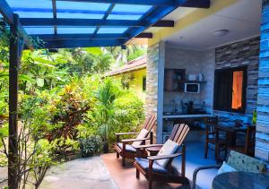 a patio with chairs and a table and a kitchen at Buisson Guesthouse in La Digue