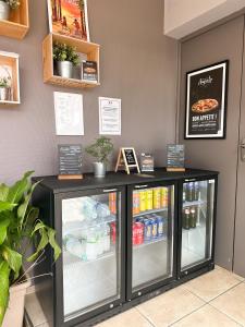 - un réfrigérateur avec des boissons à l'intérieur d'un restaurant dans l'établissement Hôtel Ecochic, Mont-de-Marsan Sud, à Saint-Pierre-du-Mont