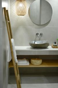 La salle de bains est pourvue d'un lavabo et d'un miroir sur une étagère. dans l'établissement Tramontana House 3, à Skiathos Chora 21 autres photos