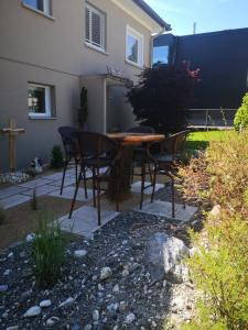 a patio with a table and chairs in a yard at Garten-Wohnung in Eschen