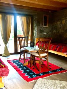 a living room with a table and chairs and a bed at Vikendice Suvo Do in Berane