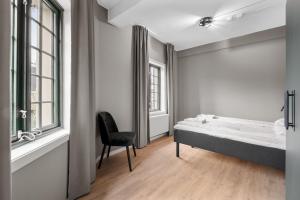 a bedroom with a bed and a chair in it at Forenom Serviced Apartments Drammen in Drammen