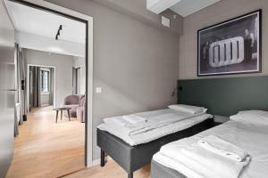 a room with two beds and a mirror at Forenom Serviced Apartments Drammen in Drammen