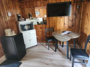 cocina con mesa y TV en una habitación en The Cove Motel & Restaurant, en Aulds Cove