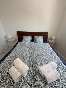 a bedroom with a bed with two towels on it at SL Apartman Siófok in Siófok