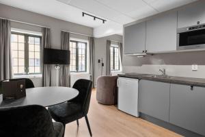 a kitchen with a table and chairs in a room at Forenom Serviced Apartments Drammen in Drammen