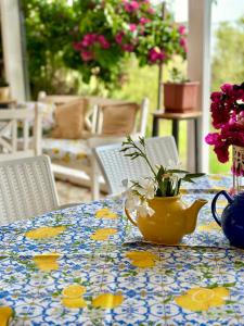 a table with a yellow vase with flowers on it at Hotel Imperial in Dhërmi