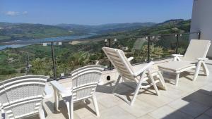 a group of white chairs on a balcony with a view at B&B Celeste - Palazzo D'Addario in Celenza Valfortore
