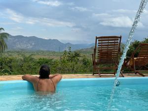 una mujer sentada en una piscina con una manguera de agua en Pousada Belvedere da Serra, en Serra do Cipo
