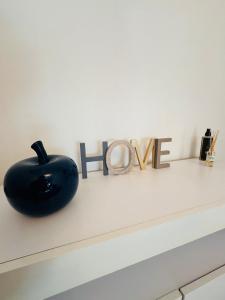 un objeto negro sentado en una mesa blanca con la palabra esperanza en Maison Lima en Collinée