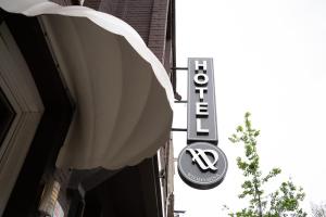 ein Schild auf einem Gebäude mit einem Schild für ein Restaurant in der Unterkunft Aadam Hotel Wilhelmina in Amsterdam