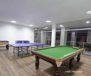 una habitación con dos mesas de ping pong. en Departamento Express CL en Vila El Carmen