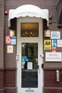 une porte menant à un bâtiment d'hôtel avec un panneau au-dessus de celui-ci dans l'établissement Aadam Hotel Wilhelmina, à Amsterdam