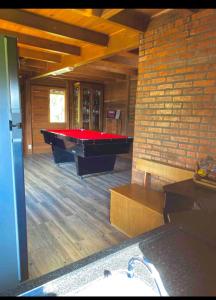 a room with a pool table and a brick wall at Chalé encanto do sol in Laurentino +15 photos