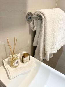 łazienka z białymi ręcznikami i białą umywalką w obiekcie Apartments Irma w Baskiej Vodzie
