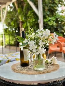 a table with two bottles and a vase of flowers at Hotel Imperial in Dhërmi