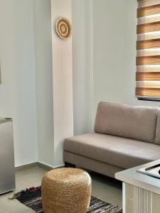 a living room with a couch and a stool at Hotel Imperial in Dhërmi
