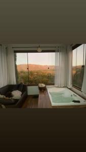 a room with a large window with a bath tub at Pousada Belvedere da Serra in Serra do Cipo