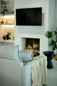 un salon avec un canapé blanc avec une cheminée dans l'établissement Tramontana House 3, à Skiathos Chora
