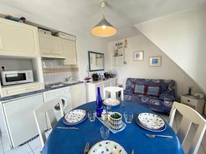cocina y comedor con mesa azul y sillas en Gaelle, Studio proche plage, en Carnac