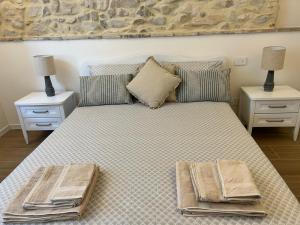 Un dormitorio con una cama con dos mesas y dos lámparas. en Dimora del Torchio, en Soiano del Lago 25 fotos más