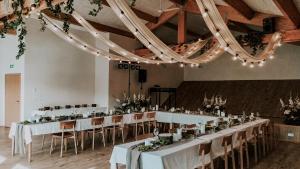 un salón de banquetes con mesas blancas, sillas y luces en Hotel Katla by Keahotels en Vík