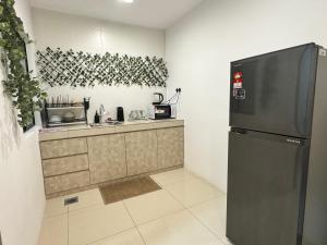 een keuken met een koelkast en een aanrecht bij Ipoh Waterpark Manhattan Premium Suites by IWH Suites in Ipoh