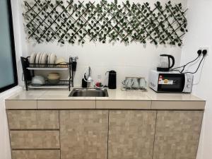 encimera de cocina con fregadero y microondas en Ipoh Waterpark Manhattan Premium Suites by IWH Suites en Ipoh