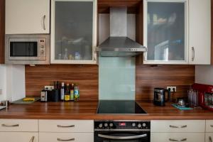 uma cozinha com armários brancos e um forno com placa de fogão em Comfortable room in central location em Hamburgo