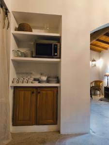 a kitchen with a microwave and a counter with dishes at Les Bergeries de Piazzagina in Piediquarciu