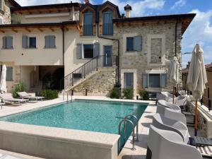 a villa with a swimming pool in front of a building at Dimora del Torchio Piscina panoramica e Jacuzzi in Soiano del Lago