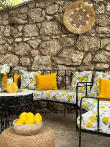 a patio with a bench and a table with a bowl of fruit at Hotel Imperial in Dhërmi