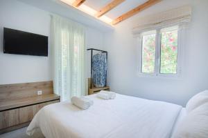 Posteľ alebo postele v izbe v ubytovaní Peroulia Beach Houses