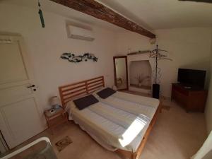 a bedroom with a bed and a flat screen tv at L'angolo Fiorito in Ugento