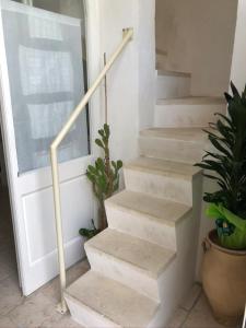 a set of stairs with a handrail next to a door at L'angolo Fiorito in Ugento