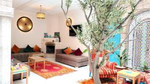 Riad Al Manara في الصويرة: غرفة معيشة فيها شجرة في الوسط