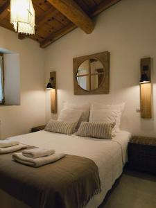 1 dormitorio con 1 cama blanca grande y espejo en Les Bergeries de Piazzagina, en Piediquarcio