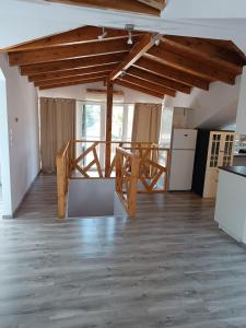 an empty room with wooden ceilings and a kitchen and a staircase at Airport Loft , paiania in Paianía