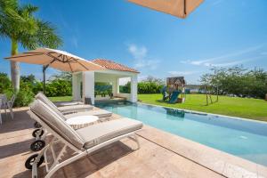 una piscina con dos tumbonas y una sombrilla en Capitalia Tres Mares Beach Residences & Marina, en Puerto Vallarta